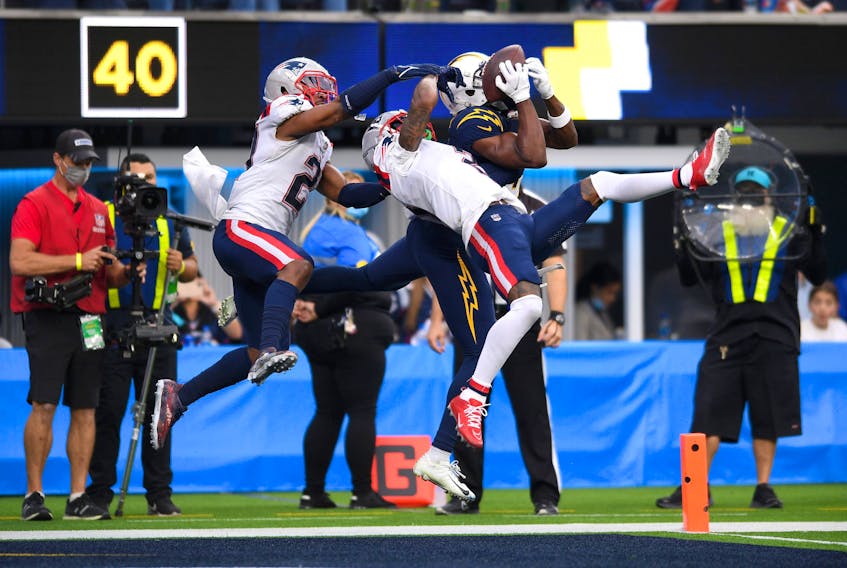  Los Angeles Chargers wide receiver Josh Palmer (5) makes a catch for a touchdown while defended by New England Patriots strong safety Adrian Phillips (21) and cornerback Jalen Mills (2) during the second half at SoFi Stadium. (Orlando Ramirez-USA TODAY Sports)