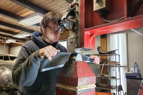 Metal craftsman creating a coupe that never existed