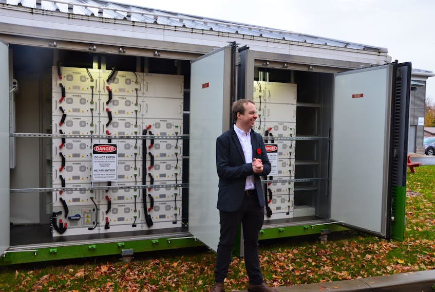 StorTera electrical engineer Scott Ledinghan with the commercial-scale StorHub battery system that has been installed at Berwick town hall. KIRK STARRATT