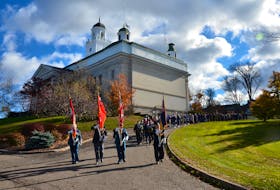 The Wolfville Legion flag party leads a Remembrance Day procession from University Hall to the Acadia University war memorial. KIRK STARRATT