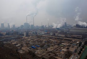 Smoke stacks and cooling towers of a power plant rise above a low-rise neighborhood that borders a steel plant in Anyang, Henan province, China. • Reuters