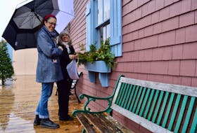 Trilby Jeeves holds an umbrella for her friend Trudi Walker, manager of Mrs. Peake’s Fancy Goods, as she decorates the window boxes of her shop on the Charlottetown waterfront Nov. 10. They are getting ready for Peake’s Wharf Christmas Village, organized by the Peake’s Merchants and beginning Nov. 12, shops will be open on the Peake’s waterfront every Friday and Saturday from 12 – 8 p.m. and Sundays 12-5 p.m. until Christmas.