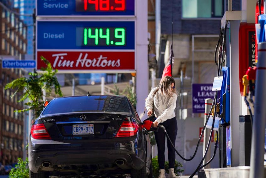 A woman fills her vehicle with fuel during the COVID-19 pandemic in Toronto on Oct. 19, 2021. 