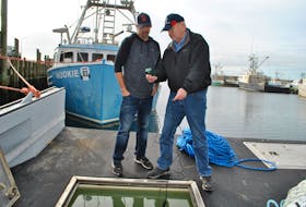 Woods Harbour fisherman Jeremy Nickerson (left) and Dan Fleck, the manager of the Lobster Quality Improvement Project for the Brazil Rock 33/34 Association, try out the oxygen meter to test oxygen levels in one of the live wells aboard Nickerson’s vessel, the Nuzzle Loader. KATHY JOHNSON


