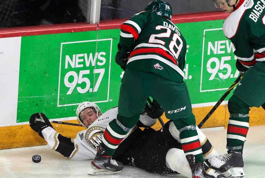 Islanders' Keiran Gallent eyeballs the puck after getting dumped behind the Mooseheads' net by Halifax's Stephen Davis early in the second period Sunday.