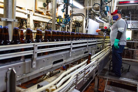 An employee at the Oland Brewery works on the production line on Monday, Nov. 15, 2021. Labatt will be expanding capacity at the brewery by importing a new pasteurizer among other investments.
