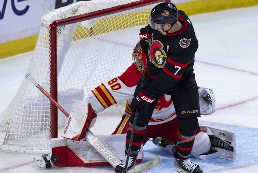 Calgary Flames goaltender Dan Vladar makes a toe save on a shot under pressure from Ottawa Senators forward Brady Tkachuk at the Canadian Tire Centre in Ottawa on Sunday, Nov. 14, 2021.