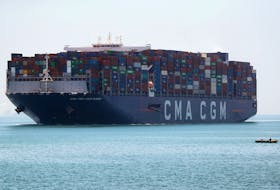 A fisherman travels on a boat in front of the CMA CGM Louis Bleriot container ship as it passes through the Suez Canal in Ismailia, Egypt July 7, 2021. 
REUTERS/Amr Abdallah Dalsh