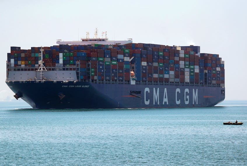 A fisherman travels on a boat in front of the CMA CGM Louis Bleriot container ship as it passes through the Suez Canal in Ismailia, Egypt July 7, 2021. 
REUTERS/Amr Abdallah Dalsh