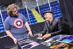 American television actor Robert Picardo, best known as The Doctor on "Star Trek: Voyager" and Coach Cutlip on "The Wonder Years," signs a photograph for Daniel White of North Sydney during CaperCon weekend in 2019 at Centre 200 in Sydney. 
CAPE BRETON POST FILE