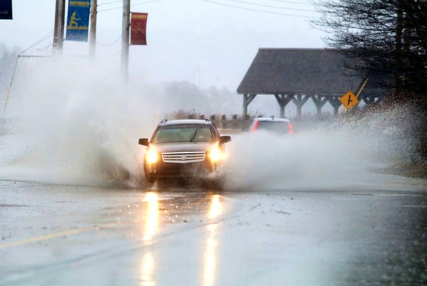 A car drives through a big puddle on Prince Albert Road in Dartmouth during a rainstorm March 22, 2019. 