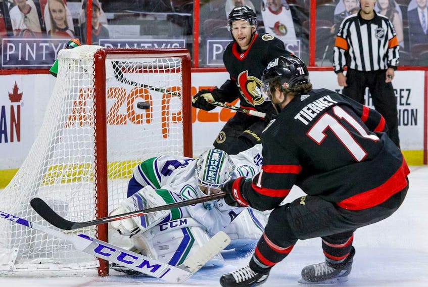 Vancouver Canucks goaltender Thatcher Demko makes a save off of Ottawa Senators centre Chris Tierney (71) as right wing Connor Brown (28) follows the play, April 28, 2021.