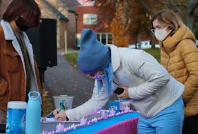 Transgender Day of Remembrance vigil attendees sign in at Rochford Square on Nov. 20. 
