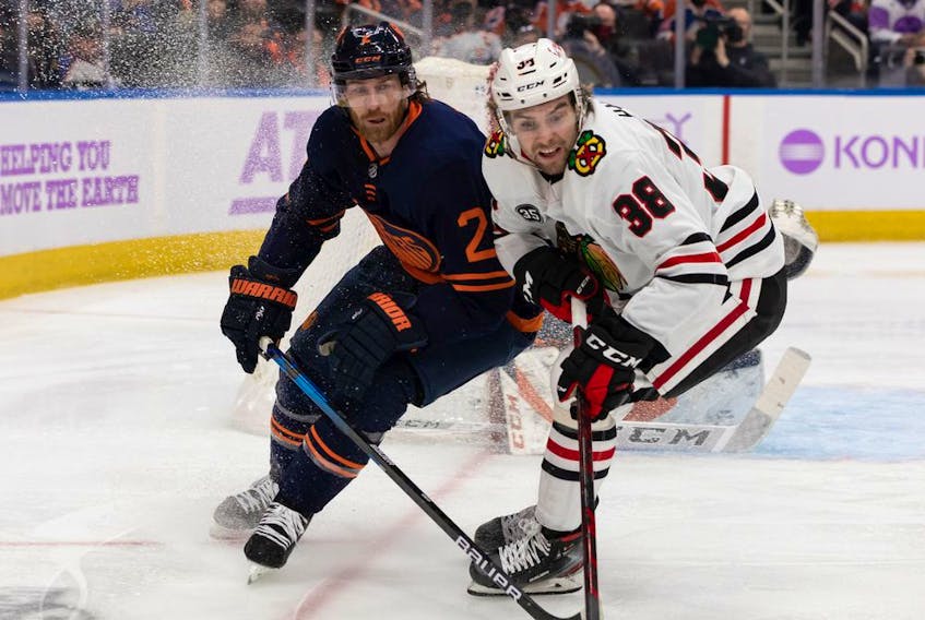 Edmonton Oilers' Duncan Keith (2) battles Chicago Blackhawks' Brandon Hagel (38) during second period NHL action at Rogers Place in Edmonton, on Saturday, Nov. 20, 2021. 