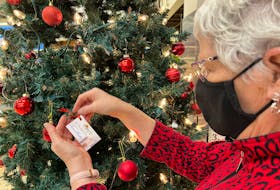 Lynda Leard hangs a decoration with the name of her late sister, Doreen Huestis, on the Memory Tree to kick off the Hospice P.E.I. Let Their Light Shine event at Superstore in Summerside on Monday, Nov. 22.