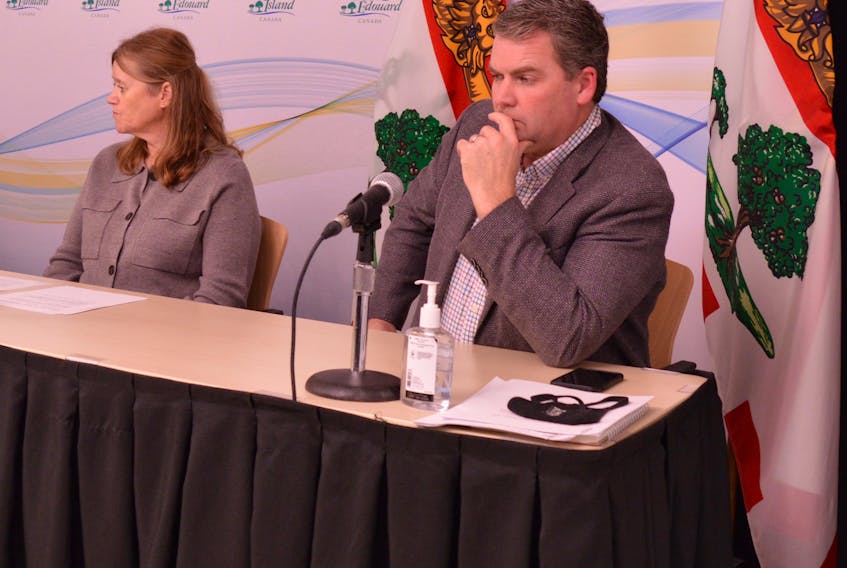 P.E.I. Agriculture Minister Bloyce Thompson, right, and Carolyn Sandford, director of Animal and Plant Health, Regulatory, and Analytical Laboratories, listen to Premier Dennis King at a Nov. 22 media briefing about the closure of the U.S. border to P.E.I. potatoes.