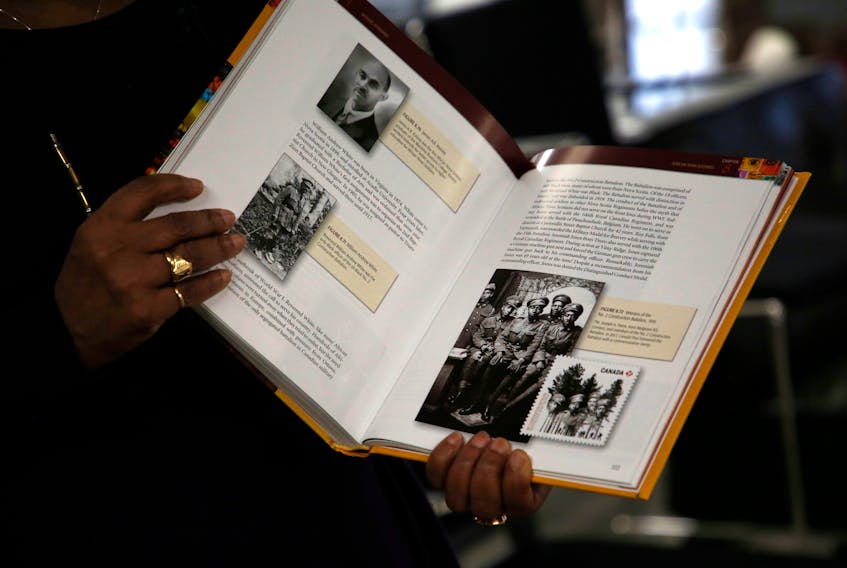 FOR PEDDLE STORY:
Sylvia Parris-Drummond is seen with a textbook of Canadian black history, that has the photo of the No. 2 Construction Battalion, one of the five men is her father, Joseph A. Parris, center,...seen in her office in Halifax Friday March 26, 2021. On Saturday the federal government is going to apologize for the racism experienced by the Battalion, a unit made up of black men.....

TIM KROCHAK PHOTO  