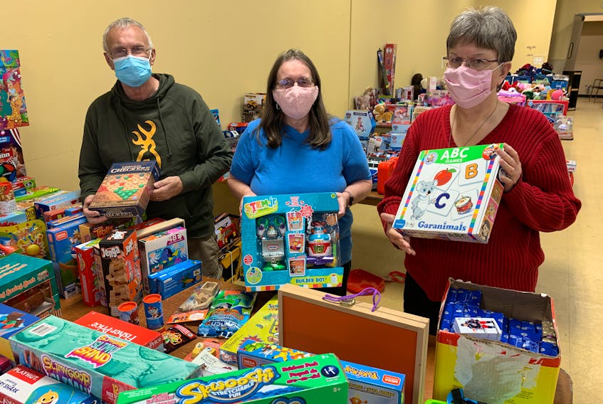 Phil Baxter, Brenda Guthrie (centre) and Barbara Baxter of the Christmas for Kids program look over some of the toys that have been donated to the annual program that ensures every child in Cumberland County has a gift under the tree on Christmas morning.