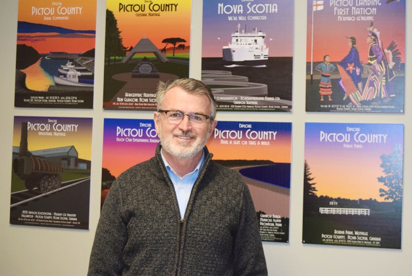 Scott Ferguson, CEO of the Pictou County Regional Enterprise Network stands in front of artwork by Pictou County's John Ashton.