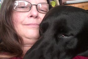 Kathi Dawn and her dog Nikita. The black lab lays her head on Dawn whenever she's not feeling well.