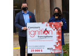 Economic Growth Minister Matthew MacKay and co-ordinator of the Francophone Ignition Contest pose with the $25,000 sponsorship to be awarded to the contest winner.