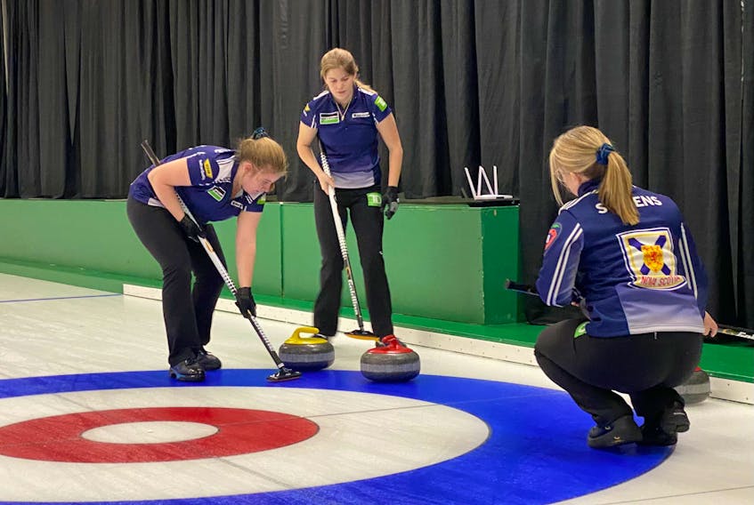 Cate Fitzgerald sweeps as teammates Lauren Ferguson and skip Taylour Stevens look on during action at the New Holland world junior qualifier in Sasktoon. The Stevens rink advanced to the semifinal against Bedford’s Isabelle Ladouceur, who skips Northern Ontario. – Darlene Danyliw / Curling Canada