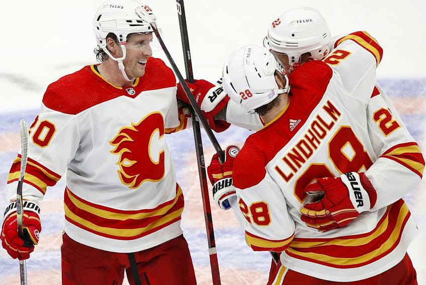 Blake Coleman (left) celebrates with Calgary Flames teammates during the club’s 3-2 win over the New York Islanders at UBS Arena in Elmont, N.Y., on Saturday, Nov. 20, 2021.