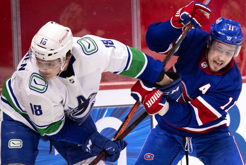 Canadiens' Brendan Gallagher (11) tries to shake off Vancouver Canucks' Jake Virtanen (18) in Montreal on March 20, 2021.  