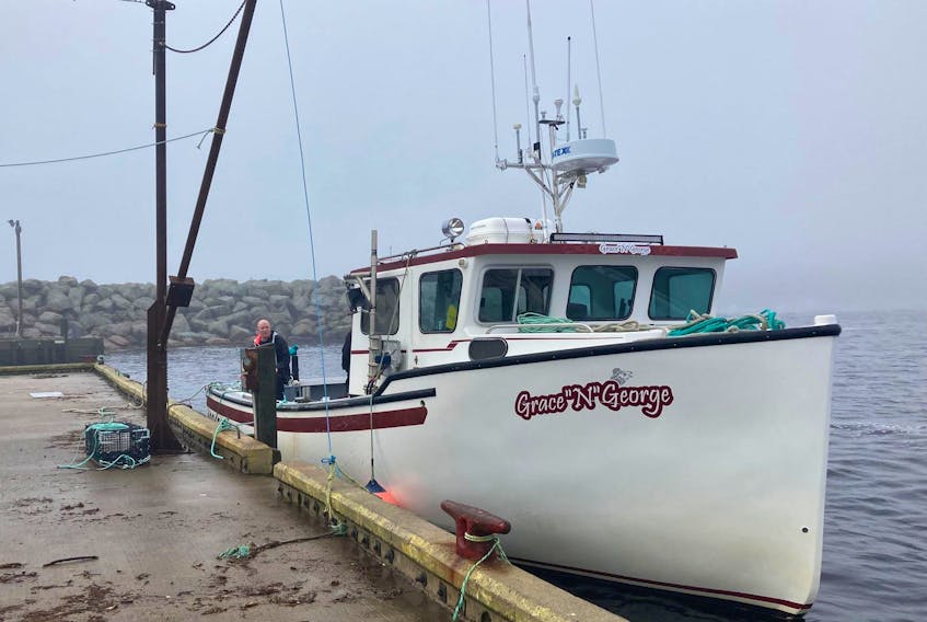 Adam Sam waits on the Grace 'n' George fishing boat for passengers to transport between Neils Harbour and Ingonish on Nov. 26, the first day water transport started to help residents who are stranded due to road washout caused by last weeks torrential rainstorm. NICOLE SULLIVAN/CAPE BRETON POST 