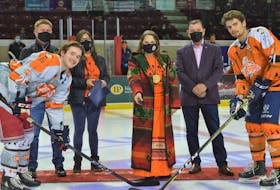 Lennox Island First Nation Chief Darlene Bernard, flanked by Maritime Junior Hockey League president Steve Dykeman, left, Lennox Island First Nation Coun. Madeline Sark and P.E.I. Sen. Brian Francis, drops the puck for the ceremonial face-off between Summerside D. Alex MacDonald Ford Western Capitals captain Josh MacDonald and Edmundston Blizzard defenceman Brendan Sibley. Both the Caps and the Blizzard players wore specially designed jerseys during the Saturday, Nov. 27 game to raise awareness about Indigenous Reconciliation following the discovery of unmarked graves at residential school sites in Canada. 
