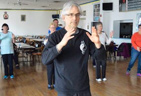 Dr. Michael Milburn is shown conducting a Tai Chi class before the COVID-19 pandemic.