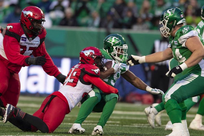  Saskatchewan Roughriders running back William Powell is tackled by the Calgary Stampeders’ Jamar Wall during the CFL West Division Semifinal at Mosaic Stadium in Regina on Sunday, Nov. 28, 2021.