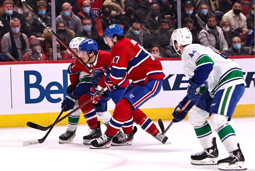 Vancouver Canucks defenceman Quinn Hughes (43) battle for the puck against Montreal Canadiens centre Jake Evans (71) and right wing Josh Anderson (17) during the second period at Bell Centre. 