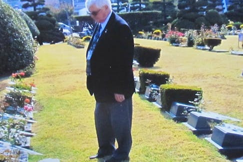 Richie MacLean stands near the gravestone of his father, Cpl. Douglas Harold MacLean, at the United Nations Memorial Cemetery in Busan, Korea.