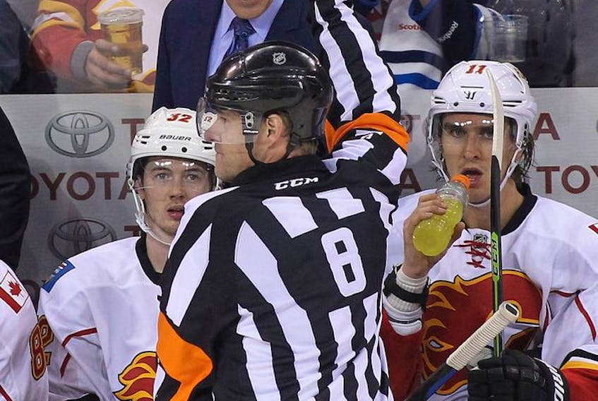  Bob Hartley, head coach of the Calgary Flames, has words with referee Dave Jackson during game against the Jets in Winnipeg on Oct. 19, 2014.