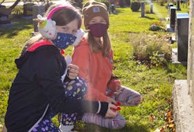 Olivia Evans, left, and Cecilia Martinez, two Grade 4 students at Eliot River Elementary School, lay a poppy at the gravestone of Cmdr. Philip Gruchy at the Sherwood Cemetery in Charlottetown on Nov. 2. The school was taking part in the No Stone Left Alone Remembrance Day ceremony where students lay a poppy at the gravestone of veterans. The ceremonies, taking place across Canada, give students and youth an opportunity to learn about and observe the sacrifice made by veterans.