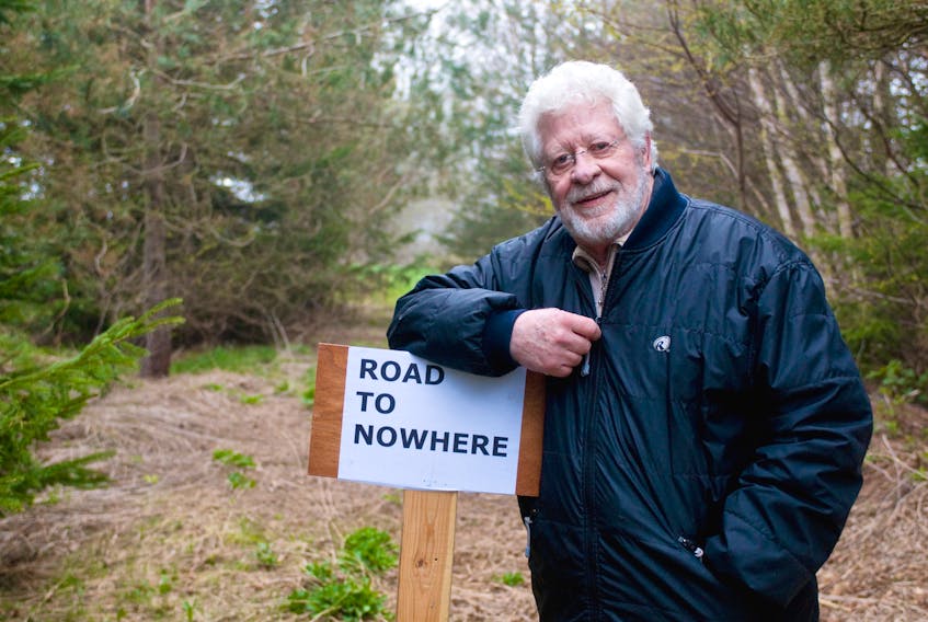 In this 2011 file photo, Ivor Sargent stands with a sign he made to bring attention to a land dispute issue over a private road he has been at odds with the P.E.I. government over since 2006. Guardian file