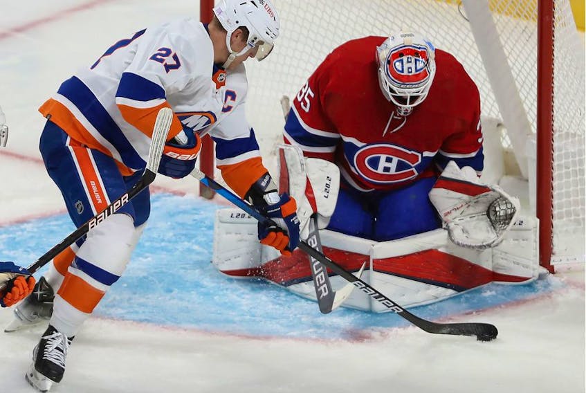 Canadiens' Sam Montembeault keeps an eye on the puck as New York Islanders' Anders Lee comes in for a shot during third period in Montreal on Nov. 4, 2021.