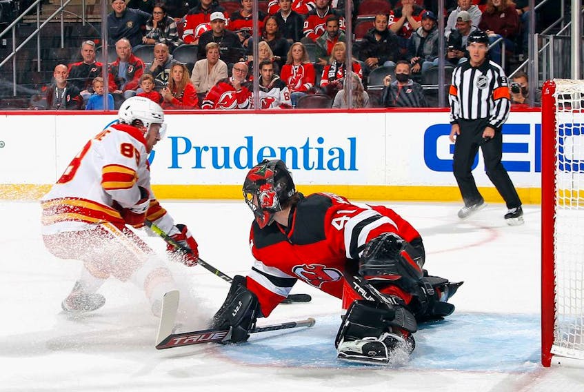  The Calgary Flames’ Andrew Mangiapane scores against New Jersey Devils goaltender Scott Wedgewood at the Prudential Center in Newark, N.J., on Oct. 26, 2021.