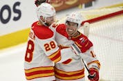  The Calgary Flames’ Elias Lindholm celebrates with Johnny Gaudreau after scoring the game-winning goal in overtime against the Washington Capitals at Capital One Arena in Washington on Saturday, Oct. 23, 2021.