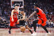 Patty Mills of the Brooklyn Nets dribbles his way through Fred VanVleet   (left) and Pascal Siakam of the Raptors during the first half at Scotiabank Arena on Nov. 7, 2021.