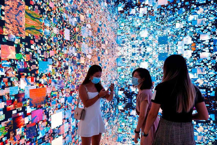 Visitors in front of an immersive art installation titled 'Machine Hallucinations — Space: Metaverse' by media artist Refik Anadol at the Digital Art Fair in Hong Kong, China on Sept. 30, 2021. REUTERS/Tyrone Siu