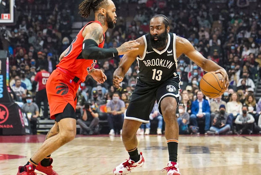 Brooklyn Nets guard James Harden (13) moves the ball against Toronto Raptors guard Gary Trent Jr. (33) during the first half at Scotiabank Arena  Sunday. 

