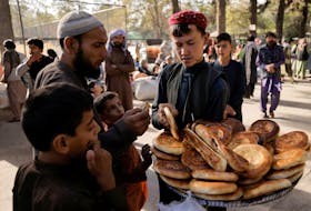 A boy sells bread at a makeshift shelter for displaced Afghan families, who are fleeing the violence in their provinces, at Shahr-e Naw park, in Kabul, Afghanistan Oct. 4.