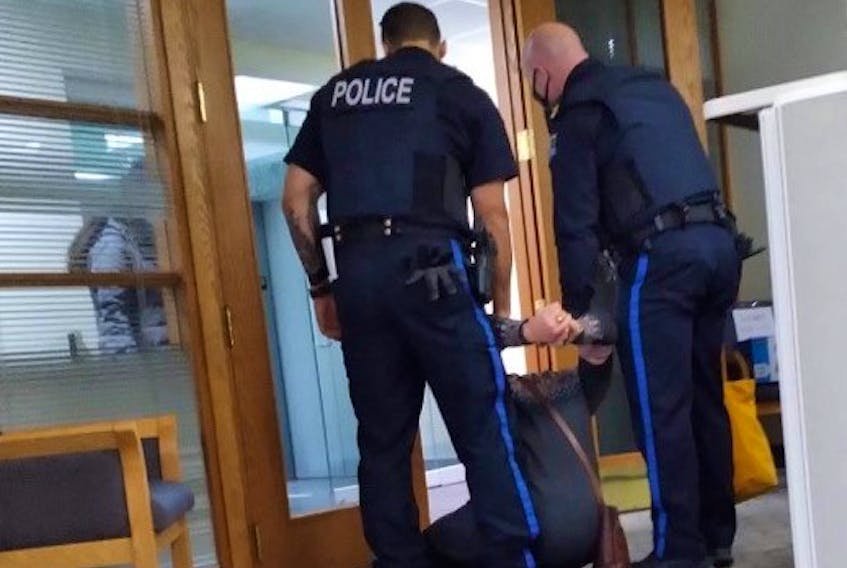 Eleanor Kure, one of two protesters arrested by Halifax regional police at the natural resources and renewables office in downtown Halifax in November 2020, is removed from the office.