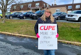 Long-term-care worker Laura Stewart stands with a sign calling for improved working conditions in Lunenuburg.