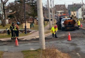 Work crews repave part of the main street of Port Morien after the installation of sewer pipes. Contributed