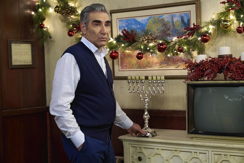 In Daniel and Eugene Levy’s new book about their hit TV show Schitt’s Creek, the latter — seen here on the show with his character's motel menorah — writes he hoped the Merry Christmas, Johnny Rose episode would reflect his real-life “manic insanity about the holiday,” despite being Jewish. (Schitt's Creek/CBC)