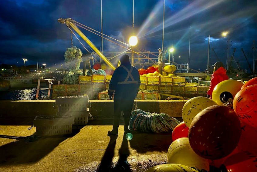 Lobster traps and gear are loaded onto boats at the wharf on Yarmouth’s waterfront on the evening of Nov. 30 as the industry prepared for the delayed start to the commercial lobster fishery. TINA COMEAU PHOTO