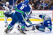 Canucks goalie Thatcher Demko makes the save as J.T. Miller checks Winnipeg Jets' Blake Wheeler during the first period at Rogers Arena in Vancouver on Friday, Dec. 10, 2021. 